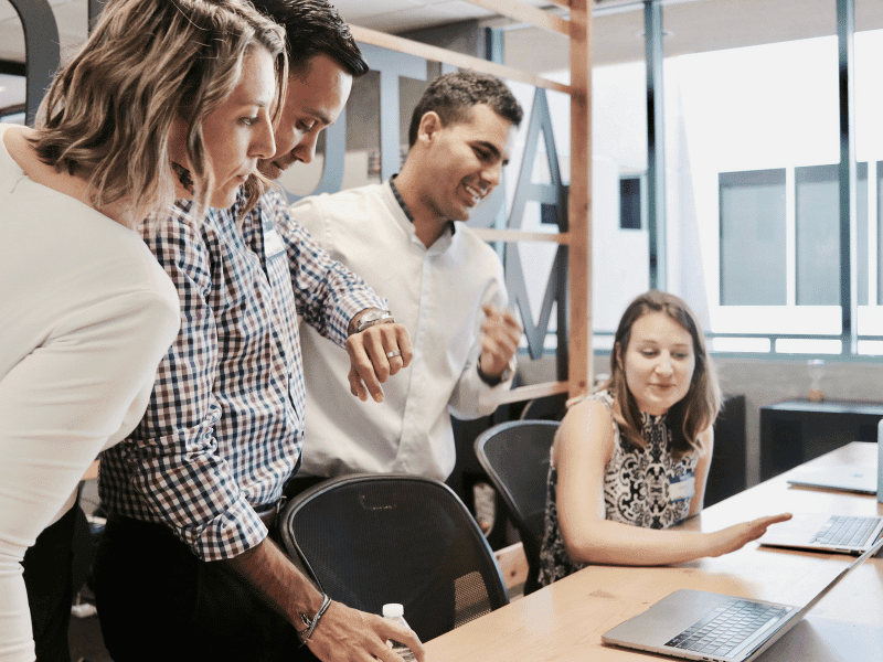 employees round a laptop